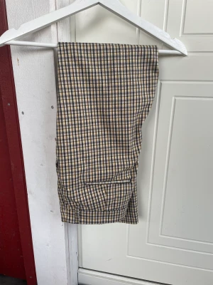 Kostymbyxor från ginatricot  - Ett par rutiga kostymbyxor från ginatricot. Anklelängd på mig som är 173 cm lång.