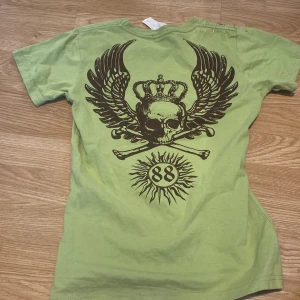 Cool T shirt  - Grön Tröja med coola tryck och rhine stones. Köpt på PMU secondhand. Det står storlek M men skulle säga att det är XS-S. Säljer för 150 kr.