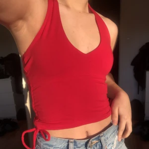 Hollister haltertop - Helt ny haltertopp från Hollister med öppen rygg och knytning på sidorna i en supersnygg röd färg!