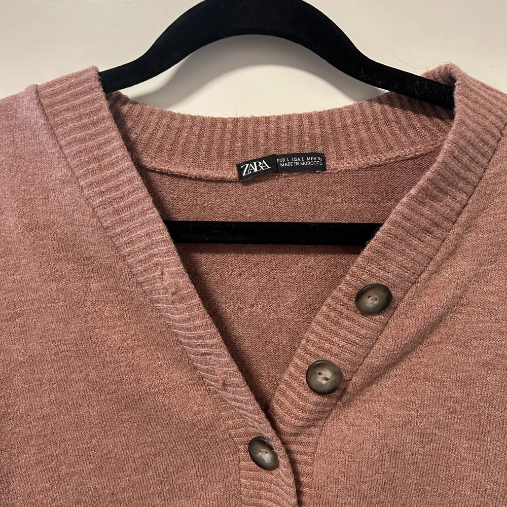 Stickad rosa/lila tröja med knappar från Zara. Aldrig använd. Storlek L men väldigt liten i storleken, skulle säga den sitter som en S/M. Toppar.