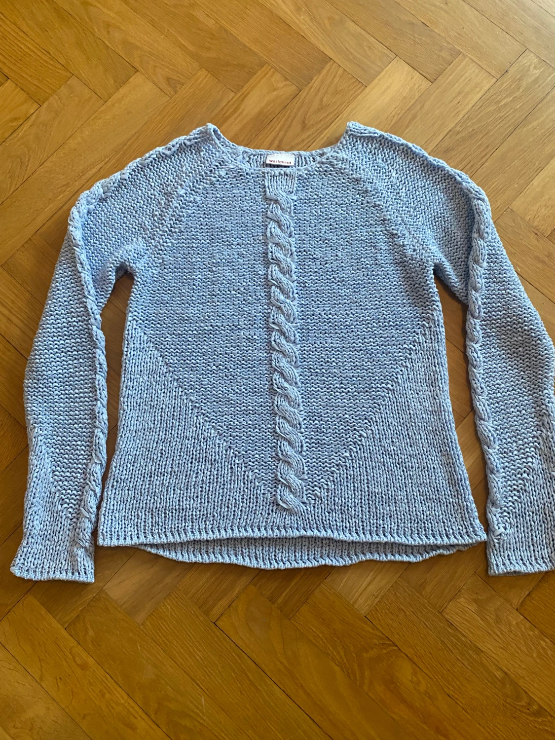 Lös stickad ljus blå tröja med flätor på armarna och i mitten partiet - 90