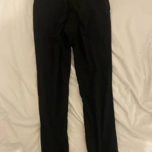 Svarta kostymbyxor  - Ett par svarta kostymbyxor i ett näst intill oanvänt skick. 
