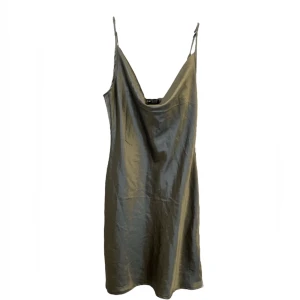 Grå-grön satin klänning  - säljer denna snygga satin klänningen som jag säljer pga att den inte kommer till mycket användning. sparsamt använd och inga defekter. om du har frågor så är det bara att kontakta mig.