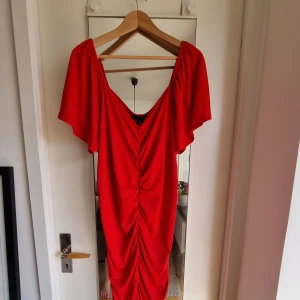 Röd plisserad klänning - Superfin klänning som går ner en bit över knät. I nyskick.