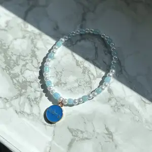 Supergulligt blått elastiskt armband med vågens tecken. Tecken på ena sidan, text på andra. Guld detaljer 🩵 frakt 15 kronor 