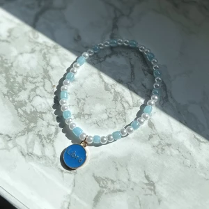 Stjärntecken-armband - Supergulligt blått elastiskt armband med vågens tecken. Tecken på ena sidan, text på andra. Guld detaljer 🩵 frakt 15 kronor 