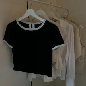 Svart kortare t-shirt från h&m med vita detaljer i strl XS