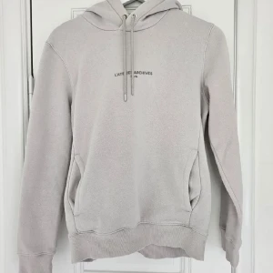Hoodie - Hoodie i gråbeige färg med en liten text på bröstet. Lite nopprig men är i övrigt i fint skick! Passar super inför höst och skolstart❤️