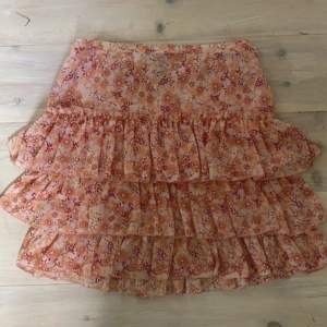 Kortare blommig kjol, storlek 38 från HM, inte tight fit. Ser mindre färgglad ut på bilden än i verkligheten :)