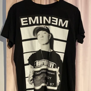 Eminem T-shirt - En helt oanvänd eminem Tshirt som jag fick av min syrra! Den kommer inte till användning då jag inte när T-shirtar så ofta annars är den i perfekt skick! :) Det är storlek L men sitter som en M