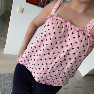 Rosa prickigt linne - Säljer detta söta linne i färgen rosa med svarta prickar💖🌸 köpte linnet på kidsavdelningen i den största storleken så den passar otroligt bra för den som har XS och S i linnen💕