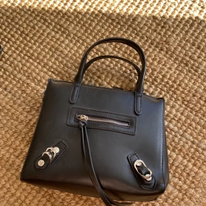 Nelly väska  - Liten väska från Nelly med avtagbart långt axelband. Superfint skick, använd 2 gånger. 