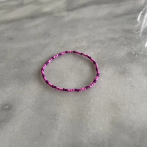 Pärlarmband - Rosa och lila pärlarmband. Normalt i storleken. 