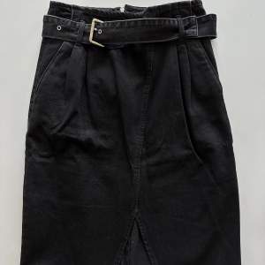 Snygg svart/grå jeanskjol med bälte och slits framtill. Dragkedja bak. Storlek 36. Använd enstaka gånger. 