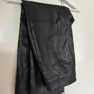 Skinnbyxor - Ankellånga aningen flaired skinnbyxor i strl 38. Aningen små i storlek så passar 36 också. Använda men i väldigt fint skick och i mjuk PU-material. Inte alls klistriga eller plastiga. 