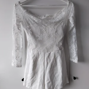 Vit playsuit - En vit playsuit som har inbyggd byst. Är i ungefär en Xs beroende på kropp. 