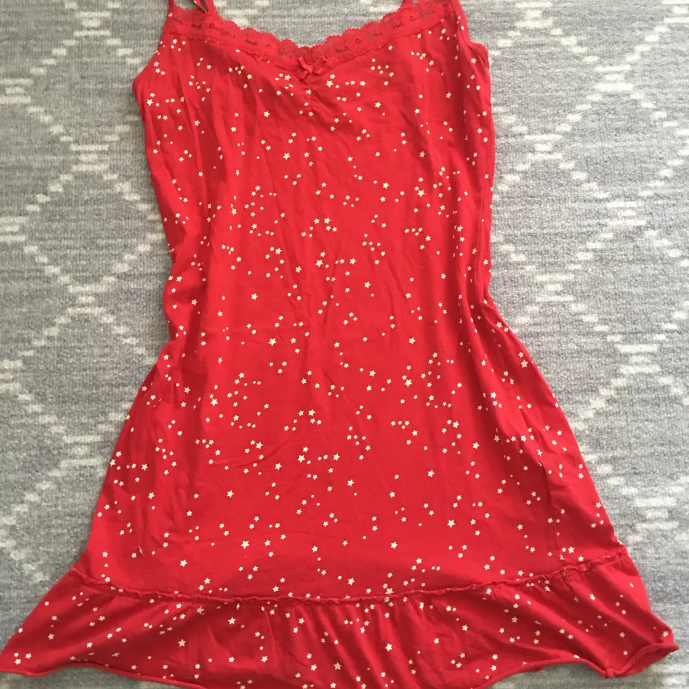 Säljer röd pjamas klänning med små sjärnor. Det går att justera på axeln och har använt några ggr men är i bra skick.. Klänningar.