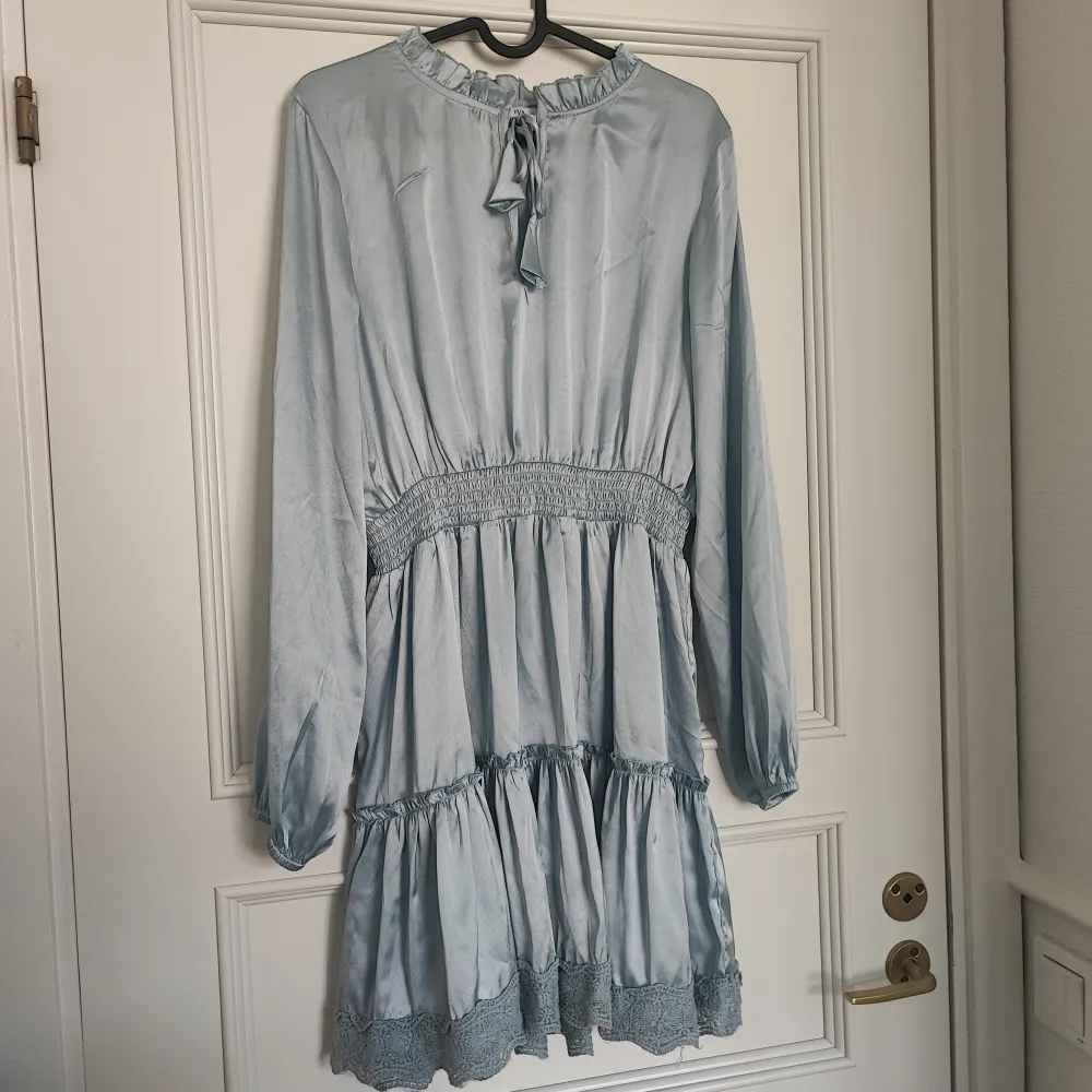 Isblå klänning i satin från Nakd, använd vid ett tillfälle så superfint skick . Klänningar.