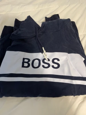 Hugo Boss hoodie  - Hugo boss hoodie mörkblå okej skick, storlek L eller M minns inte är ganska lång i storleken. 
