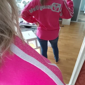Disneyworld tröja strl S - Cerise långärmad tröja från Disneyworld storlek small. Rymlig modell, smalare nertill. Bomull men jag gillar lite tunnare material så använder den aldrig. Jag är en medium o kan ha den, jag är 157 lång.