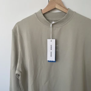 Helt ny Samsøe Samsøe tröja! - Helt nyköpt och oanvänd tröja från Samsøe Samsøe. Nypris 1100kr. Prislapp sitter kvar. Till herr, passar dam om man gillar lite oversize.  Finns en S och en L! 