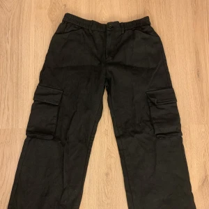 Cargo byxor - Oanvända svarta cargo byxor som är så coola😍 Lågmidjade! Innerbenslängd-71