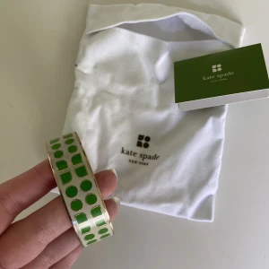 Kate spade armband  - Sååå sött Kate Spade armband i guldig metall och grönt-vitt mönster 💚🤍 Köpt early 00s i USA men används inte längre. Är stämplad på insidan med Kate Spade o dustbag+tag kommer med 🥰💘💕 Sååå unikt och playful! Perfekt skick! 