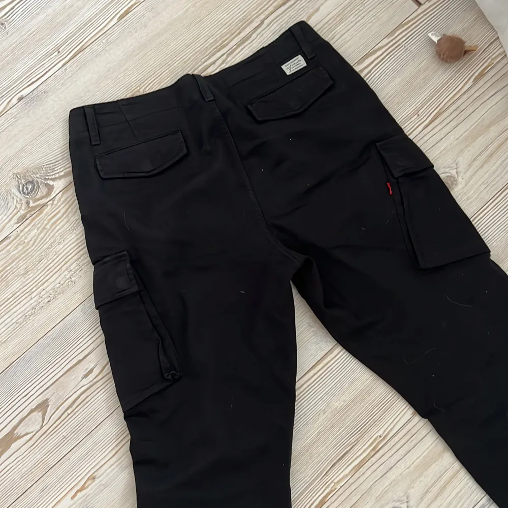 Svarta cargo jeans från levi’s, använda i jättegott skik. Jeans & Byxor.