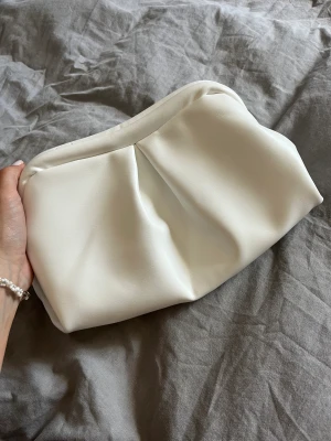 Clutch-väska - Superfin clutch / väska i skinnimitaion. Går även att använda som necessär 🤍 finns öglor på insidan (bild 3) så går att sätta i ett band men har tyvärr inget band som medföljer. Endast använd vid 1 tillfälle så fint skick! 