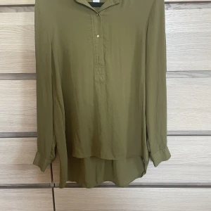 Olivgrön blus - Tunn tyg och detaljer i guld Fin skick  