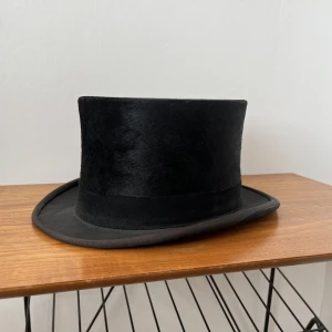 Svart vintage cylinderhatt  - Superfin cylinderhatt i svart.  Vintage, retro, använd och har fläckar inuti i toppen, men annars fin på utsidan!  Storlek 57.