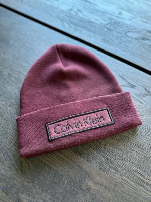 Calvin Klein Mössa - Säljer min fina Calvin Klein mössa. Sparsamt använd och som ny! 