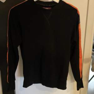 Säljer en parajumper tröja pågrund av att tröttna att använda den, den är i storlek 164/S och är i bra skick, den är svart och orange, köpt nypris för 2100.