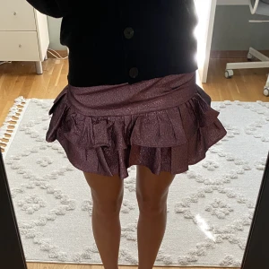Glittrig kjol - Fin glittrig rosa volangkjol med inbyggda shorts. Bra skick!