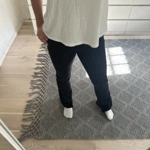 bootcut jeans - Svart/grå bootcut jeans med klippt slit i. Storlek 27/32 men skulle säga att de passar 34/36. 
