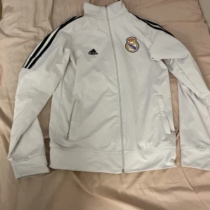 Real Madrid kofta - Säljer en Real Madrid kofta i väldigt billigt pris. Bra kvalitet och knappt använd. Storlek L. Hör av er. 