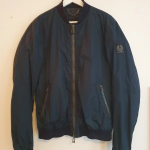 Belstaff blå bomberjacka strl 50 - Bellstaff blå bomberjacka strl 50, vilket motsvarar en storlek M. Använd men I väldigt gott skick, skitsnygg!