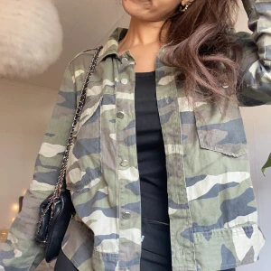 Kamouflage jeans jacka - Säljer denna super coola kamouflage jeans jackan perfekt nu till hösten😍💕🙏🏼Är i en storlek 36 och köptes från Sellpy och kommer ursprungligen ifrån Gina Tricot. Saknar två knappar men inget man tänker på (bild👉🏼).