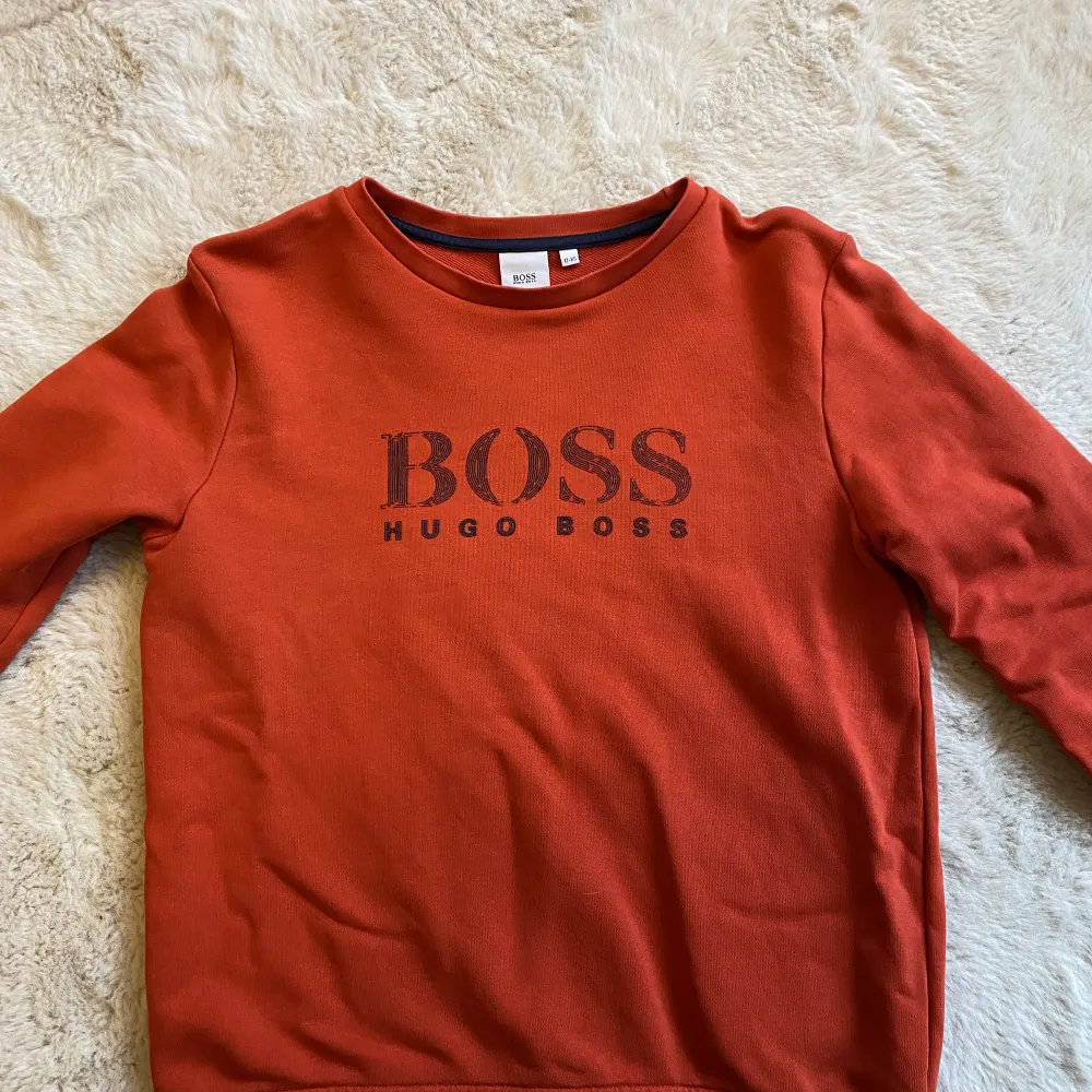 Röd Hugo Boss tröja i strl 12 år (xs), ev liten fläck nertill på ena ärmen, se bild . Tröjor & Koftor.