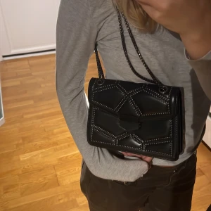 Väska - Väska som går att ha på två sätt. Spännet är lite krångligt 