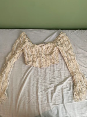 Topp från NA-KD  - Säljer en beige långärmad topp från NA-KD i storlek 38. Endast använd en gång. 