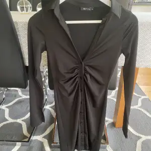 Svart knapp klänning från Nelly i Xs, säljer då den inte kommer till användning längre. 150kr + frakt