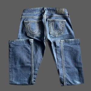 True Religion - Så fina true religion lågmidjade jeans i rak modell! midjemåttet: 38cm tvärsöver innerbenslängd: 71cm