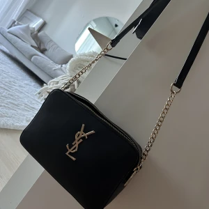 Axelremsväska YSL - Axelremsväska med två fack/dragkedjor. 