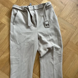 Beiga kostymbyxor - Beiga kostymbyxor från & other stories! Är i bootcut stil men är korta i ankeln och sitter ganska tajt. Storlek 36. Aldrig använda!