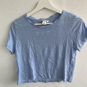 Ljusblå croptop med hjärtan - Tunn croptop med lös passform. Använd få gånger
