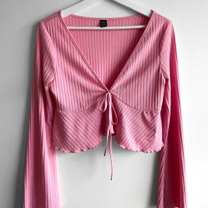 Rosa knyt blus  - Rosa långärmad blus. Ärmarna är utsvängda och finns ett snöre man knyter vid bröstet. Är i storlek L men är super liten i storleken? Passade min vän som hade storlek S🌸 Endast testat på. 