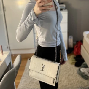 Vit väska - Säljer denna väldigt fina, fräscha och nästan helt oanvända Yves Saint Laurent väskan💞Den är ej äkta💞 Pris kan diskuteras❤️