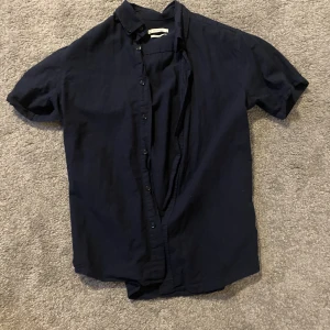 Kortärmad linne skjorta  - Säljer nu min mörk blå linne skjorta då jag inte har nån användning av den, Den är in princip i ny skick då jag bara har använt den en gång🤩Det är bara att ställa frågor! Kan sänka priset vid intresse och snabb affär.