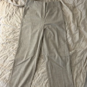 Utsvängda kostymbyxor - Beige linnemix, ”fejkfickor” baktill. Bra skick knappt använda. 